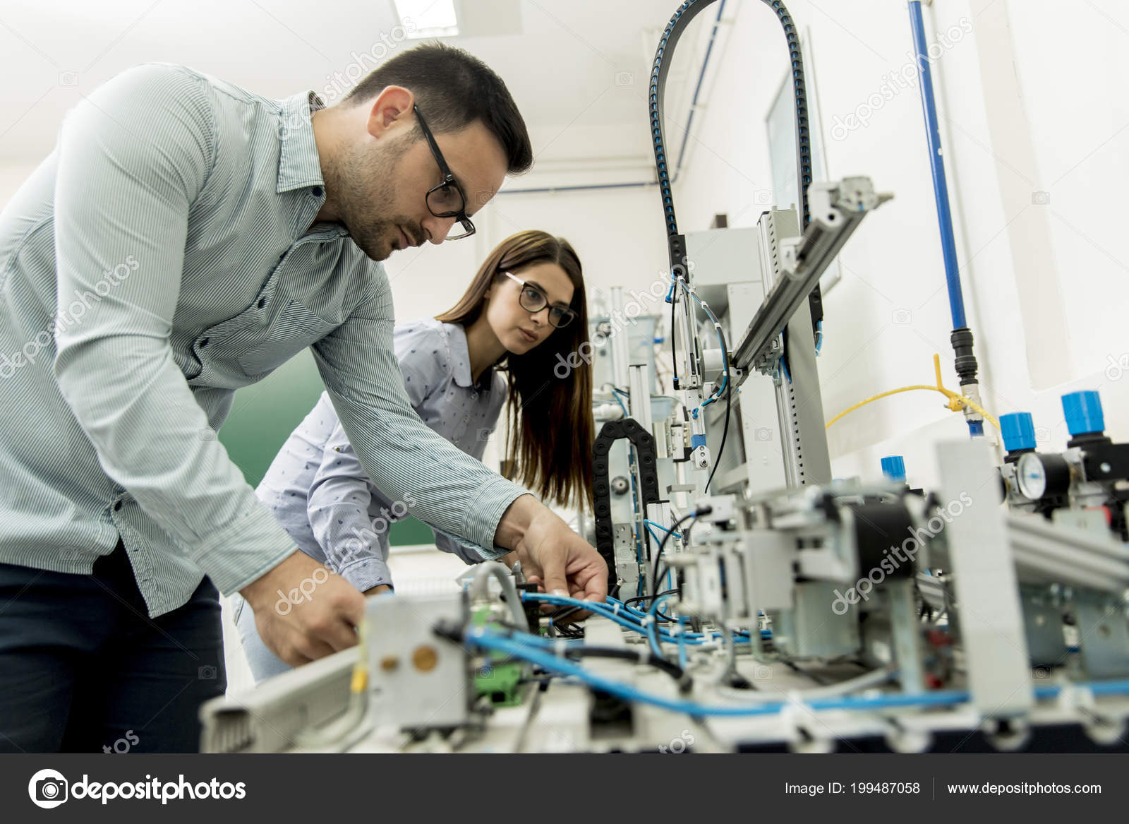 Young couple of students working at robotics lab